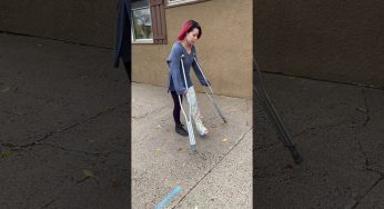 AJ crutching through down sidewalk